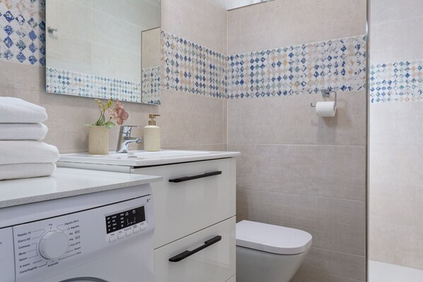 Une salle de bain moderne avec des toilettes, un lavabo et un miroir.