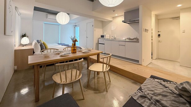 A modern, compact apartment with a dining area, kitchen, and a bedroom with a large window. - Arts Dobashi 3N (Hiroshima)