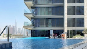 A modern building with a swimming pool, large windows, and a view of the city skyline. - Silkhaus Canal Front 9 A tower (Dubai)