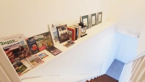 Eine Treppe mit einer Sammlung aus Büchern und Postkarten an der Wand.