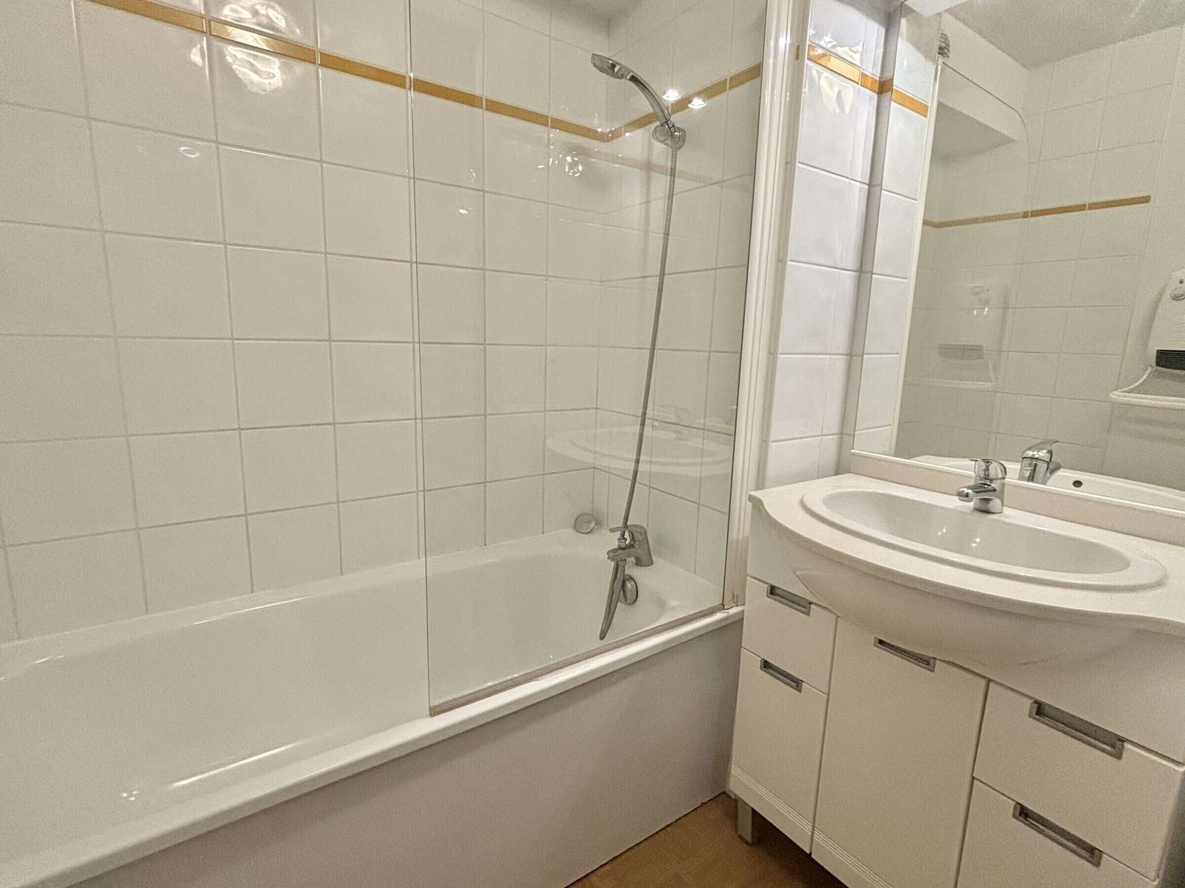 A bathroom with a bathtub, shower, and sink.