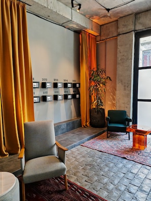 Un intérieur moderne comprenant un coin salon, une plante en pot et un mur avec des boîtes de rangement numérotées.