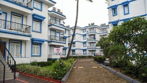Un edificio residencial con varios balcones, una señal de zona silenciosa y un sendero pavimentado.