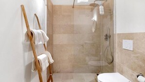 Et moderne badeværelse med bruseniche, en træhåndklædeholder og et toilet.