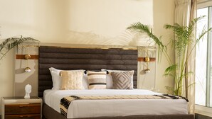 Une chambre à coucher moderne avec un grand lit, des tables de chevet et une petite table de nuit.