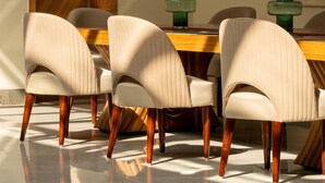 Un coin repas avec une porte en bois, une table entourée de chaises et des bougeoirs verts.