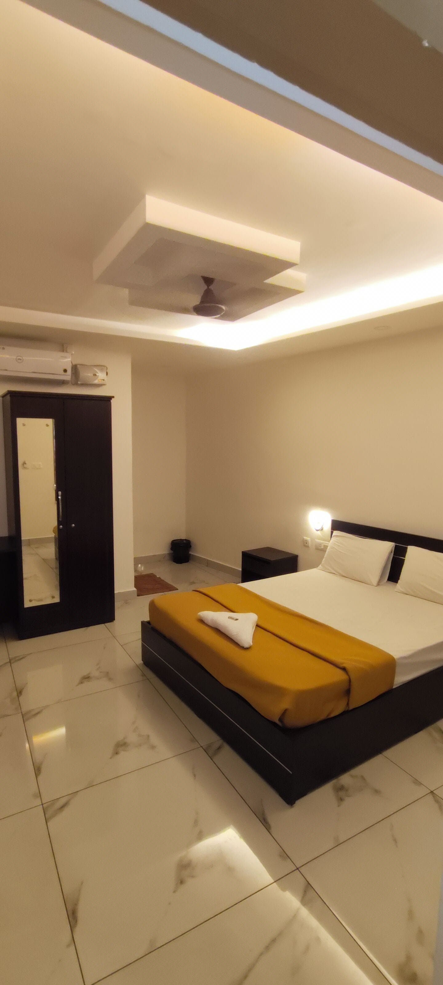 A modern bedroom with a bed, bedside table, and a wardrobe.