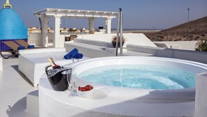 Hidromasaje con champán y fresas, sillones blancos y una estructura en forma de cúpula azul.