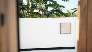 Una pared blanca con un zócalo negro y una pequeña placa rectangular.