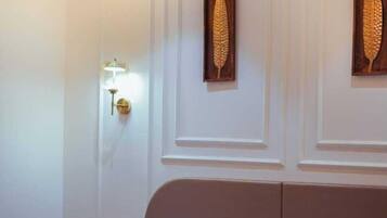 Una habitació d'hotel amb un llit, una làmpada penjada a la paret i dos panells decoratius.