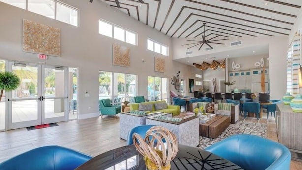 A spacious lobby with a modern ceiling design, comfortable seating areas, and large windows allowing natural light. - 6BR Resort Villa Near Disney | Private Pool 2584 (Kissimmee)