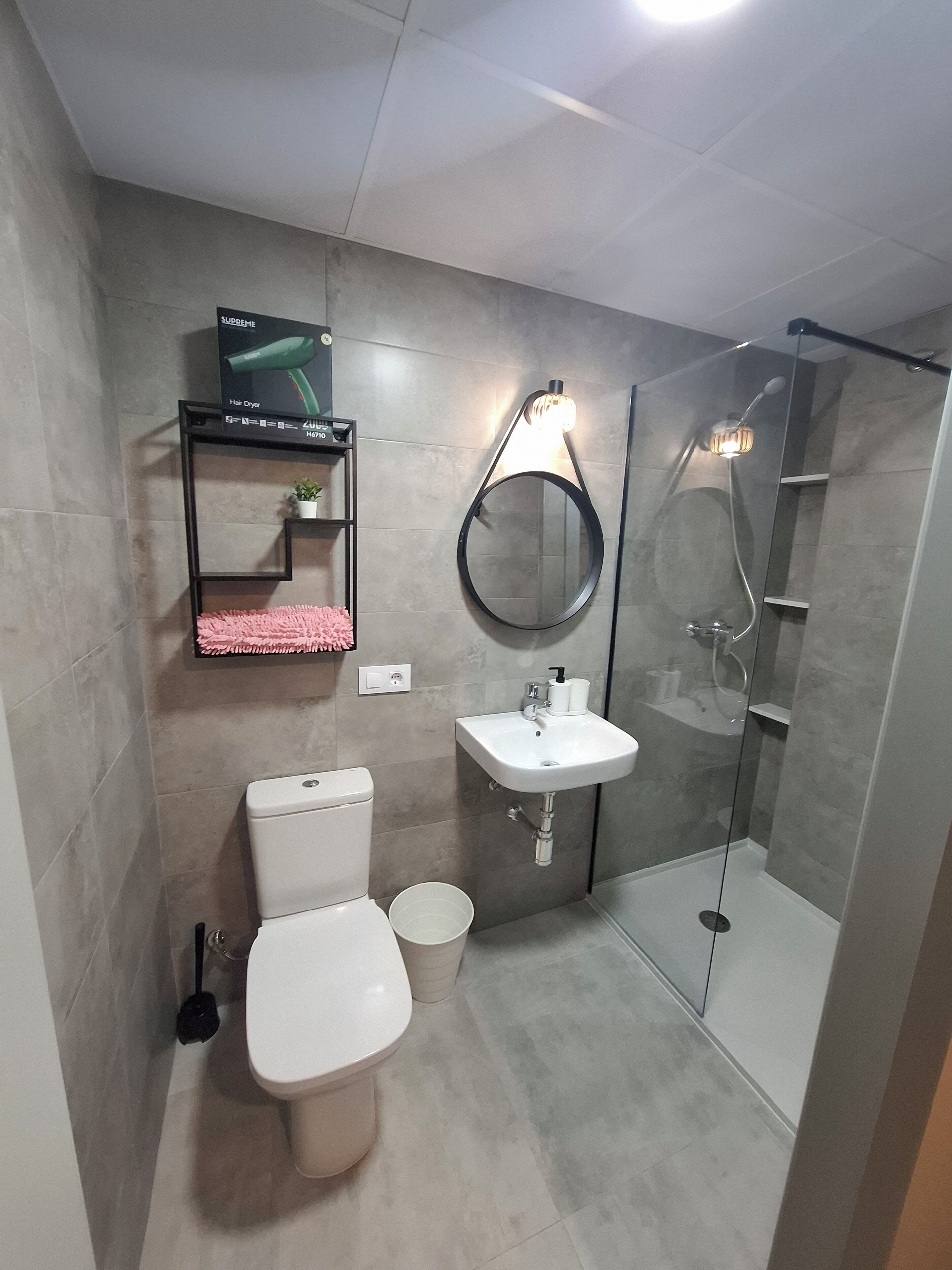 Uma casa de banho moderna com sanita, lavatório e cabine de duche em vidro.