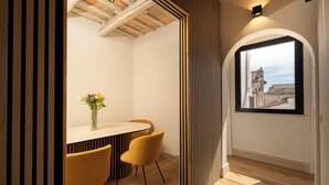 Un espace repas moderne avec un plafond en bois, une table ronde et deux chaises jaunes.