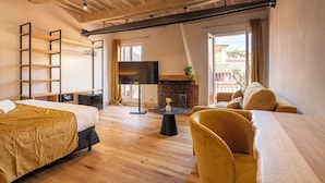 Une chambre moderne équipée d’un lit, d’un canapé, d’une télévision et d’une cheminée.