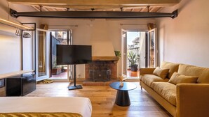 Un salon moderne avec une cheminée, un plancher en bois, un canapé, un téléviseur et une table à manger.