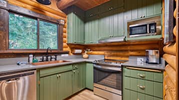 A kitchen with wooden cabinets, a microwave, an oven, and a sink.