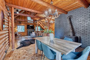 Ein rustikales Blockhaus-Interieur mit Essbereich, Kamin und Schornstein.