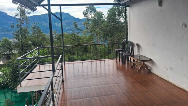 Ein Balkon mit Blick auf Berge und Bäume.