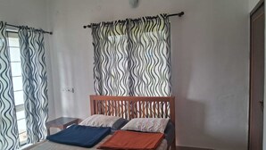 Ein Schlafzimmer mit Bett, Vorhängen und einem hölzernen Kopfteil.