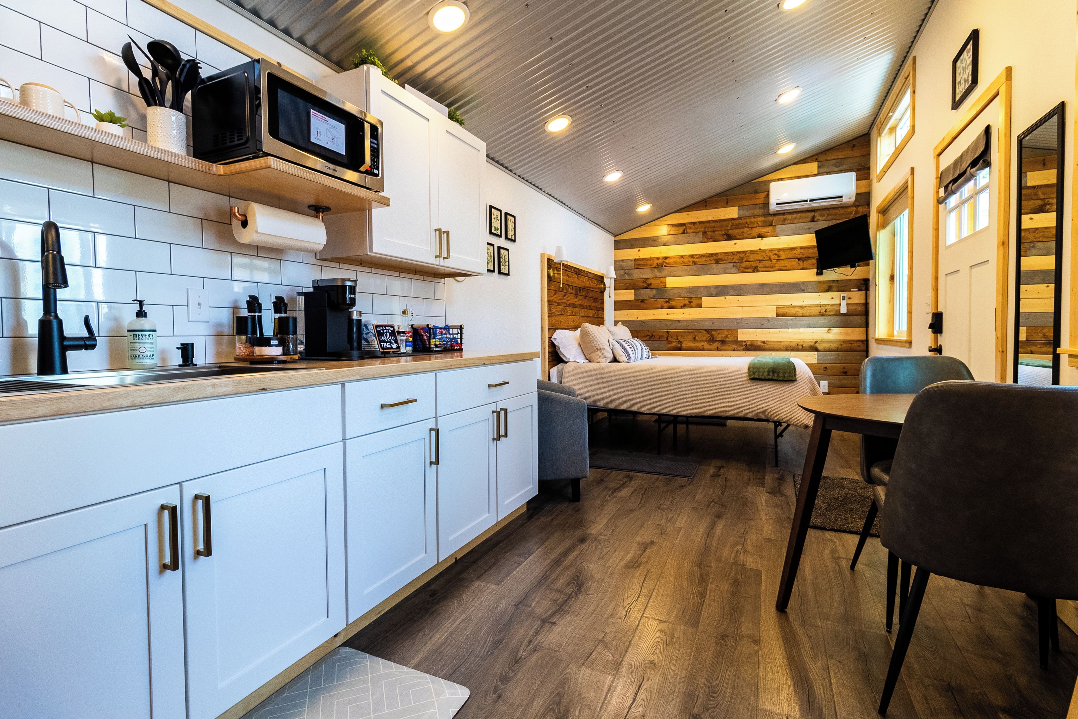 A compact kitchen with a microwave, sink, and various kitchen items.
