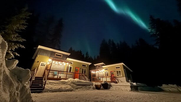 A two-story lodge with a snow-covered front yard and a visible staircase leading to the entrance. - Orange Poppy - Seward Alaska Modern Forest Tiny Home Retreat Near Kenai Fjords (Seward)