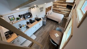 A compact, modern apartment with a kitchenette, a bed, and a dining area. - Orange Poppy - Seward Alaska Modern Forest Tiny Home Retreat Near Kenai Fjords (Seward)