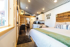 A compact bedroom with a bed, a desk, and a chair. - Orange Poppy - Seward Alaska Modern Forest Tiny Home Retreat Near Kenai Fjords (Seward)