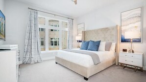 A bedroom with a large bed, a bedside table, a lamp, and a window with curtains. - Spacious 3-bedroom apartment with AC, WiFi in amazing Kissimmee (Kissimmee)