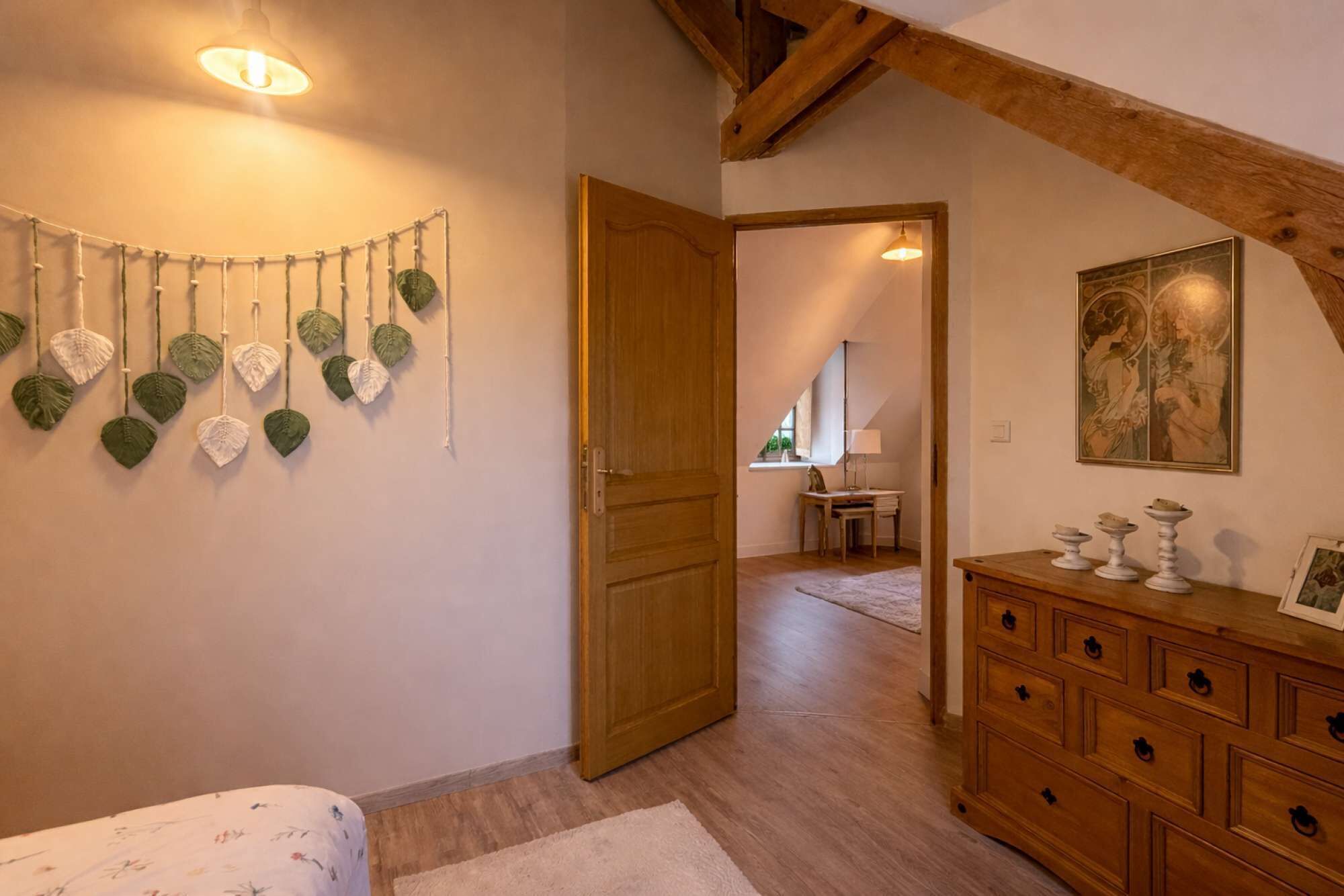 A room with a wooden ceiling, a bed with a floral bedspread, a wooden dresser, and a wall-mounted plant decoration.
