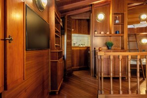 A wooden interior with a kitchen area, wooden cabinets, and a staircase. - Portofino Sea View Home in Paraggi (Santa Margherita Ligure)