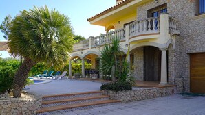 A resort with a pool, outdoor seating, and a stone facade. - Spacious villa with private pool near the beach in Costa Brava (Sant Pere Pescador)