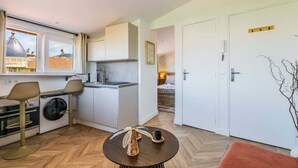 Ein kompakter Wohnraum mit Küche, Essbereich und Schlafzimmer.