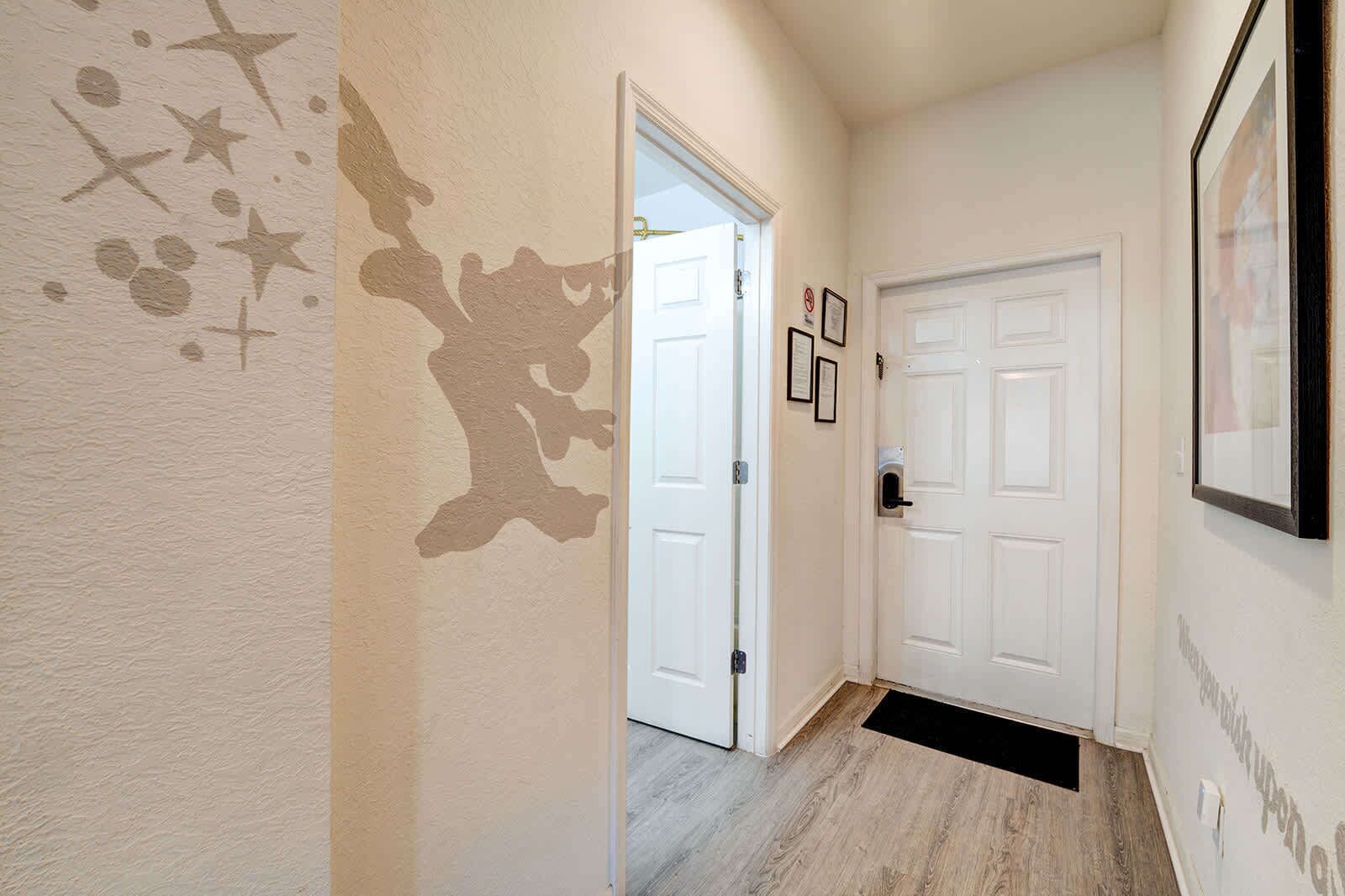 Entryway with light wood flooring and a whimsical wall mural.
