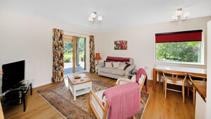 Ein Wohnzimmer mit Sofa, Fernseher und Essbereich.