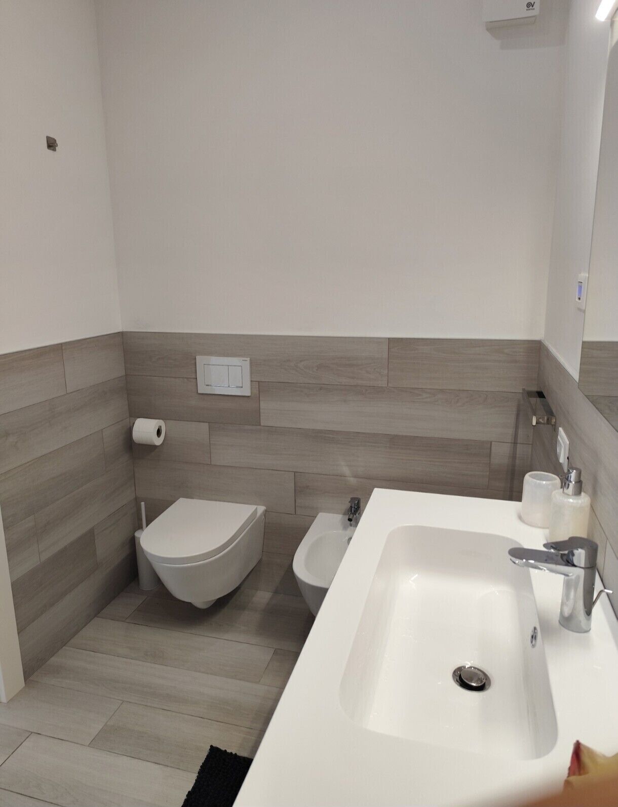 Une salle de bain moderne équipée de toilettes, d’un bidet et d’un lavabo.