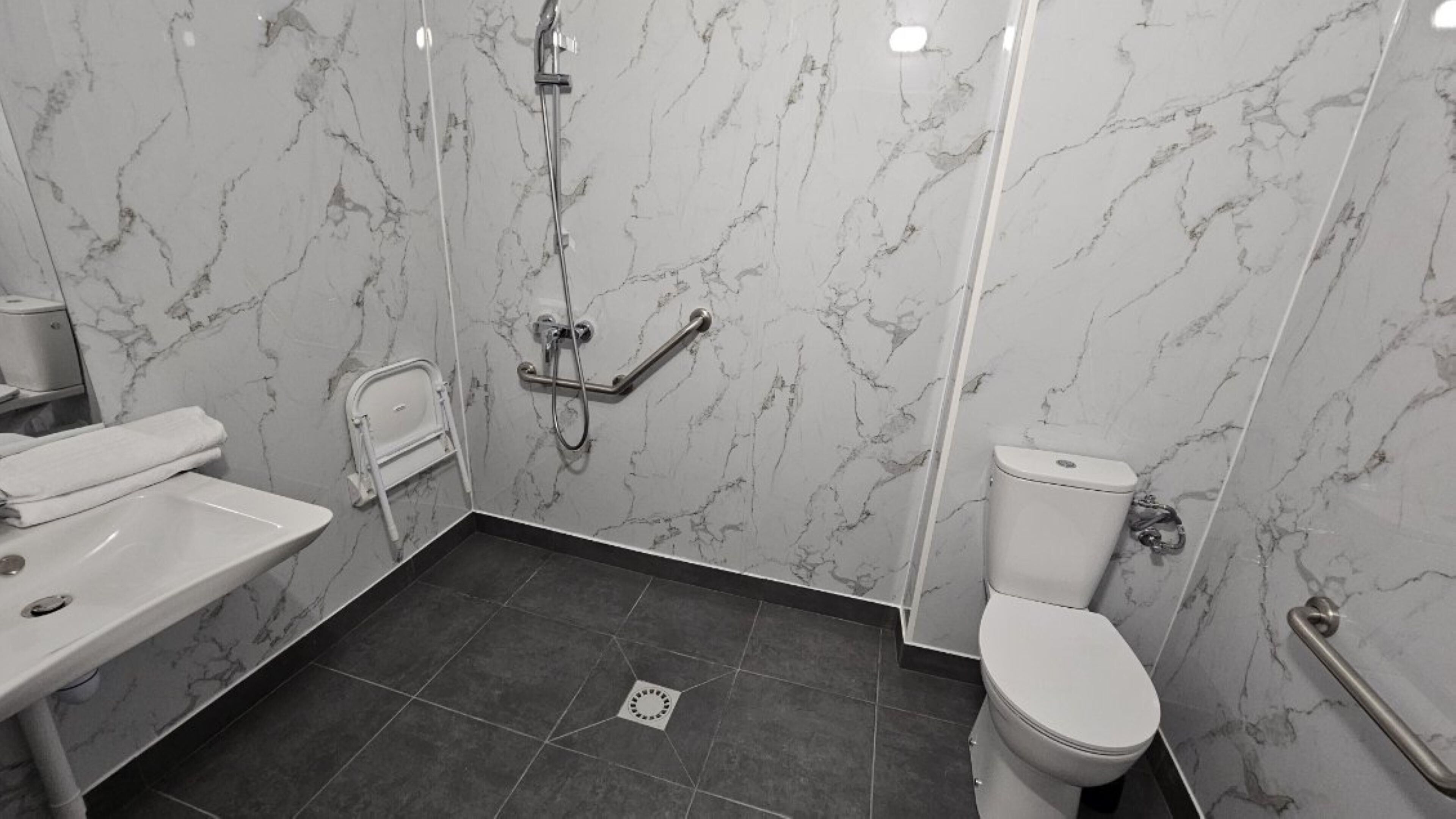 Une salle de bain comprenant des toilettes, un lavabo et un espace douche.