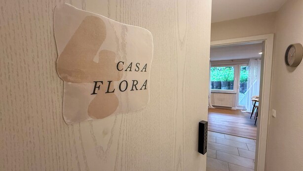Un pasillo con un letrero que dice "CASA FLORA" en la pared.