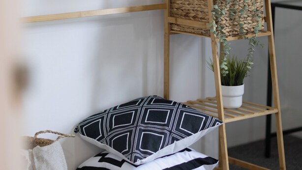 A wooden shelf unit with multiple storage compartments, including shelves, baskets, and hanging space. - Castle View Haven-Quirky and Cosy 5 Bedroom in Strood/Rochester with Castle view (Rochester)