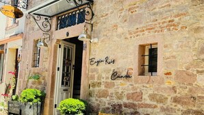 Un bâtiment en pierre avec une enseigne indiquant « Ergin Rekt » et « Cunda ». Il y a deux chaises en osier à l’extérieur.