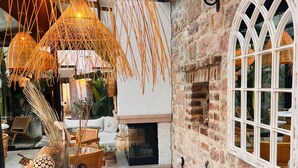 Un espace extérieur aménagé avec une table ronde, des chaises blanches et un parasol décoratif.