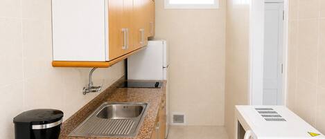 A compact kitchen with a coffee maker, a microwave, and a sink.