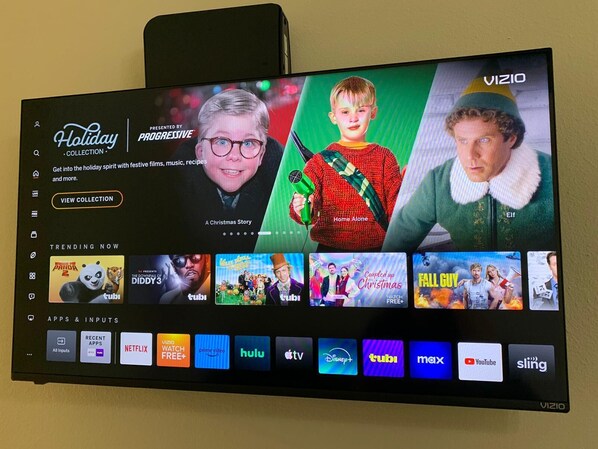 A TV screen displaying a holiday collection interface with options for festive films, music, and recipes.