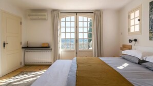 A bedroom with a bed, a radiator, a window with curtains, and a door. - Country house with private pool, quiet comfort & nature (Seillans)