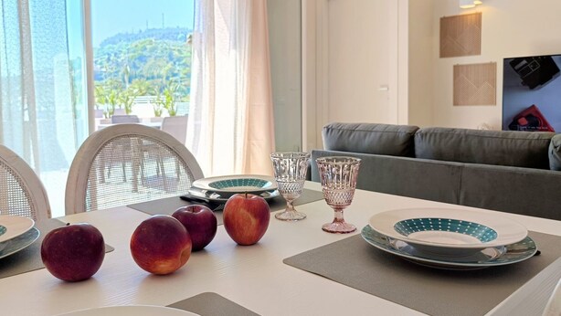 A dining area with a table set for four, including plates, glasses, and apples.