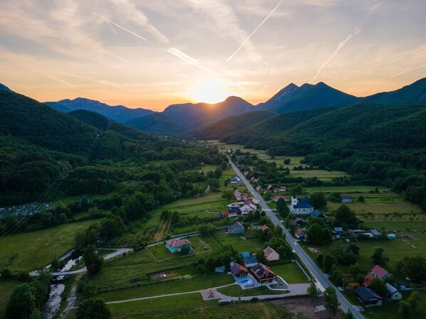 Vista aérea de un pueblo pequeño con una calle principal, casas y vegetación circundante.