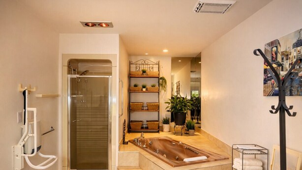A modern bathroom with a glass shower enclosure, a freestanding bathtub, and a shelf with plants. - L`urbaine. Piscine creusée. (Trois-Rivières)