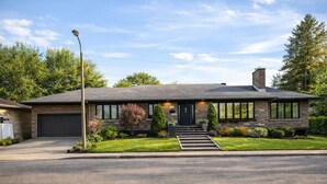 A modern single-story house with a garage, a front entrance with steps, and a well-maintained lawn. - L`urbaine. Piscine creusée. (Trois-Rivières)