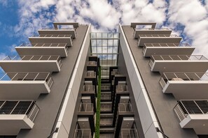 Ein modernes Gebäude mit mehreren Stockwerken, großen Fenstern und einem zentralen Atrium.