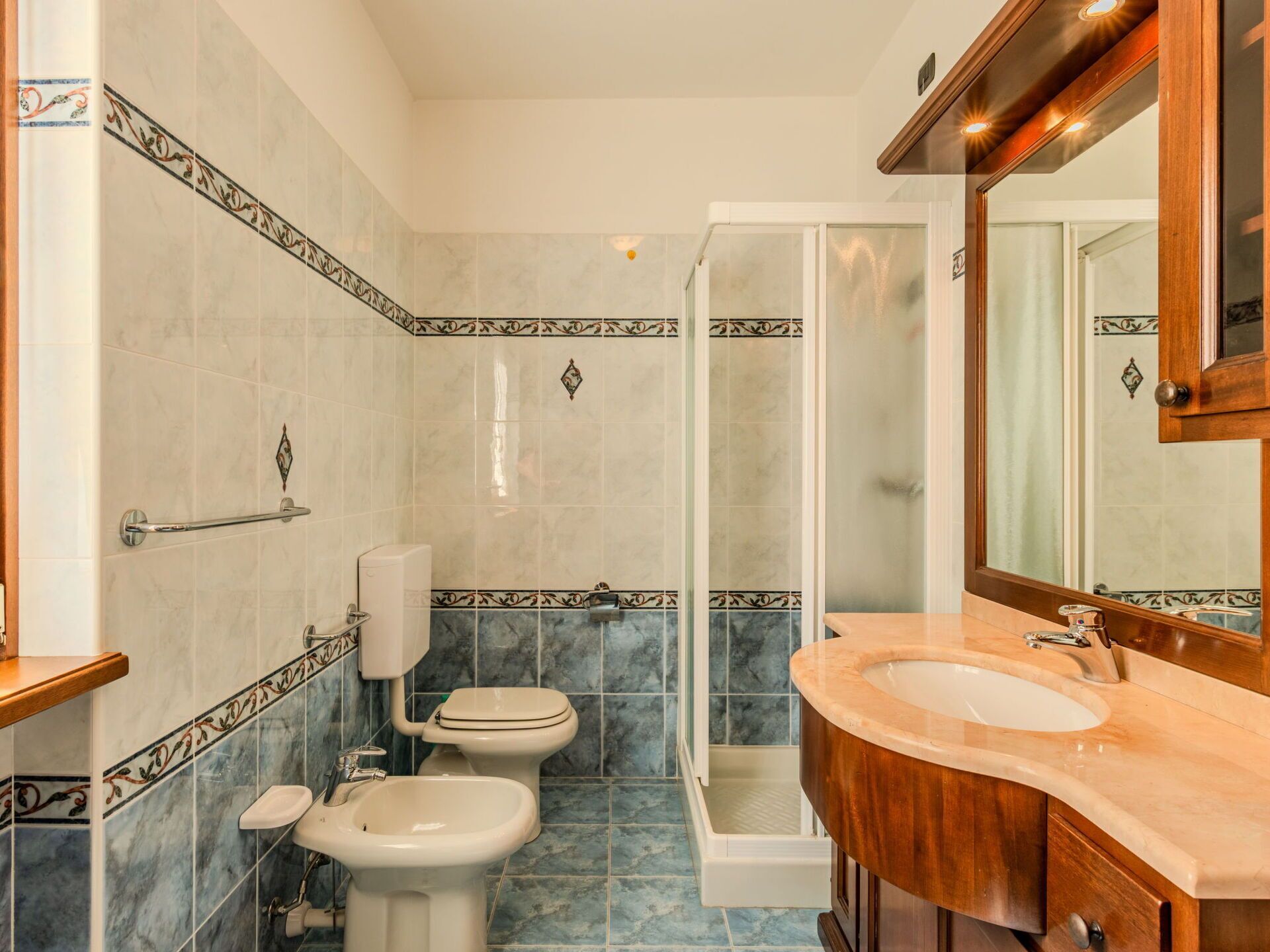 Un bany amb dutxa, vàter, bidet i rentapel.