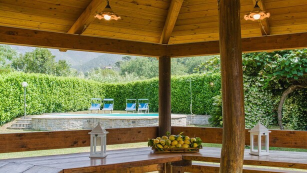 A wooden pavilion with a pool, benches, and a view of a mountainous landscape. - Cosy apartment for 6 guests with A/C, private pool, WIFI, TV and terrace (Casarza Ligure)